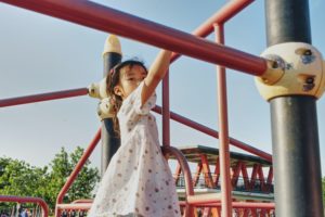 young girl playing on playground equipment