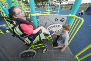 youg girl in wheelchair enjoying playground equipment