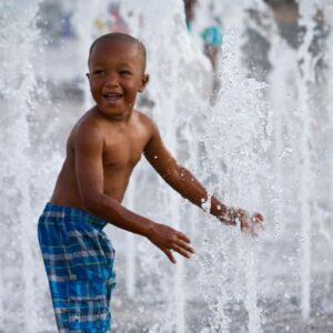young boy playing in a splash pad