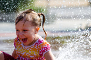 young girl experiencing water play benefits