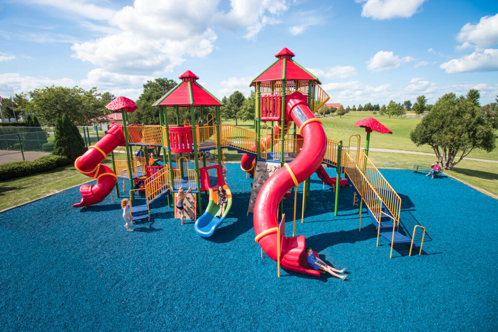 large playground with multiple tall slides that children are using