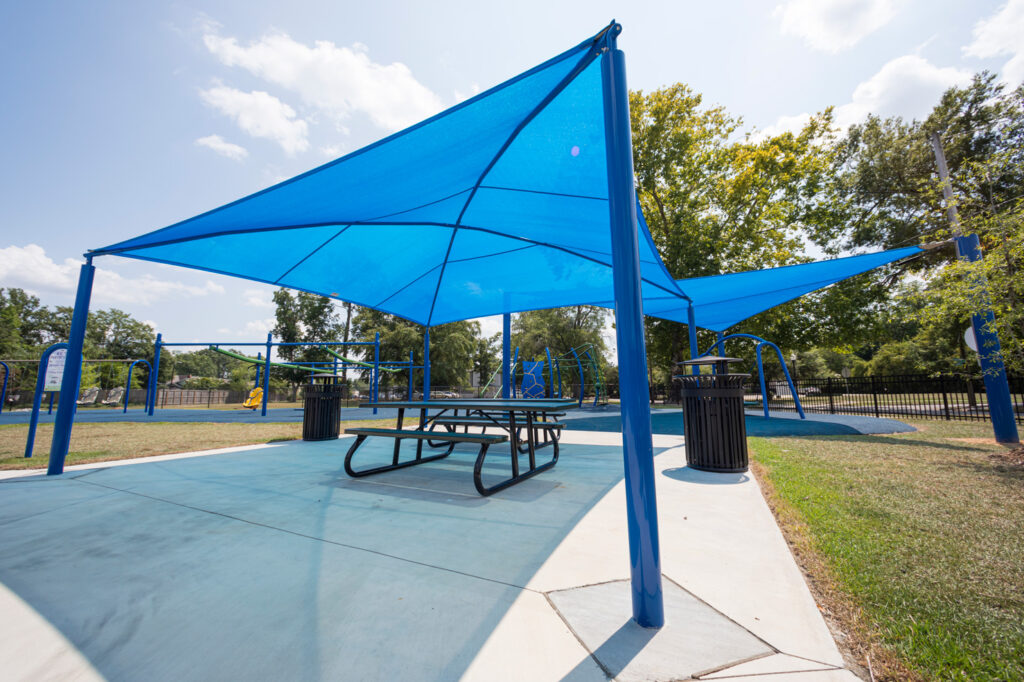 large blue shade structure covering picnic tables