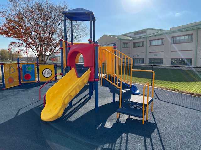 small slide playground structure that is red, yellow, and blue