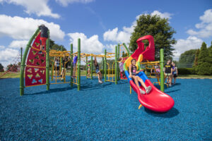 children playing at a park with blue playground surfacing