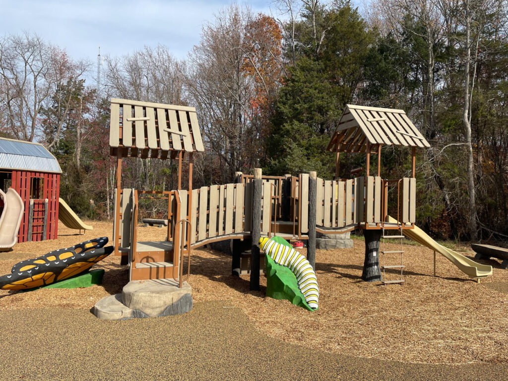 playground equipment designed to look like a natural structure and features plastic bugs