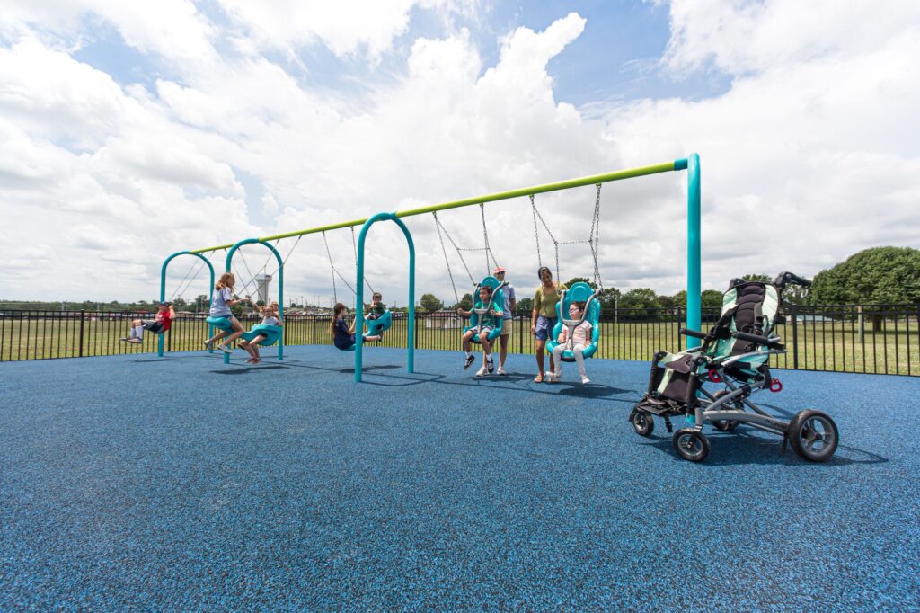 Swing set installed on blue playground surfacing