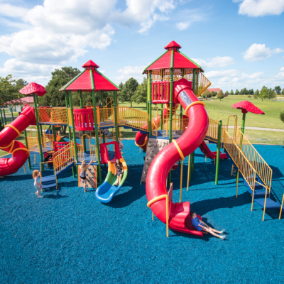 large playground with multiple tall slides that children are using