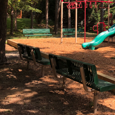 green benches surrounding the perimeter of a local playground
