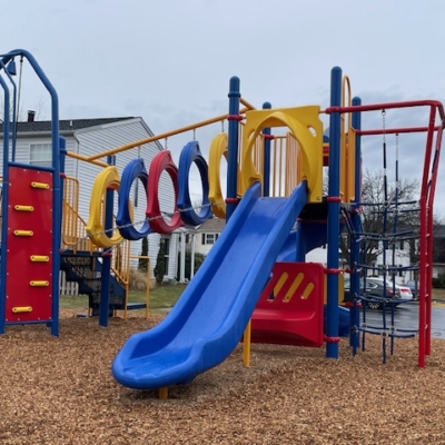 red, yellow, and blue playground with climbing components and slides