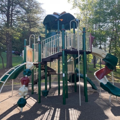 large playground structure that is red, green, and tan colored