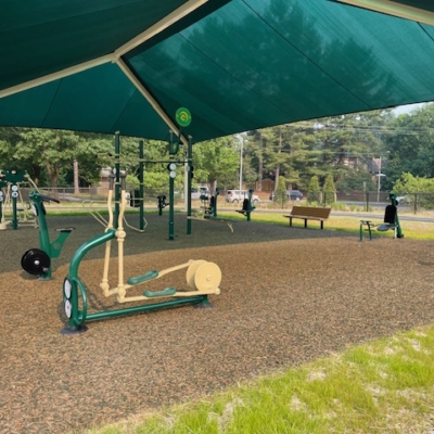 collection of outdoor fitness equipment under a large shade structure