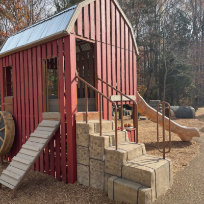 playground structure built to resemble a barn and has a slide