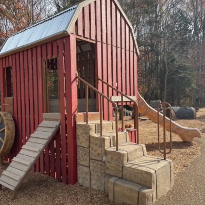playground structure built to resemble a barn and has a slide