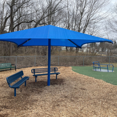 large umbrella shade structure covering two benches
