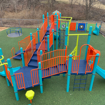 colorful playground structure in the colors dark blue, orange, sky blue, and lime green