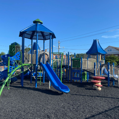 large blue and green playground structure with slides and climbing components