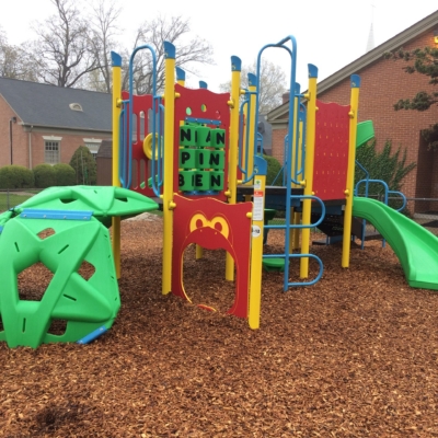 small local playground that is red, yellow, green, and blue