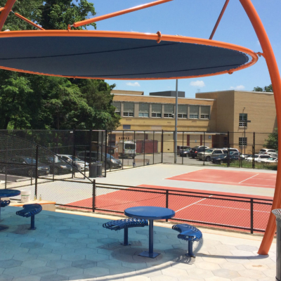large orange shade structure installed by tennis courts